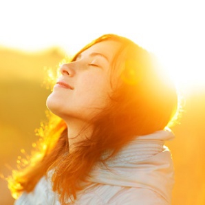 young girl with sun behind her