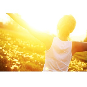 young girl in field with sun