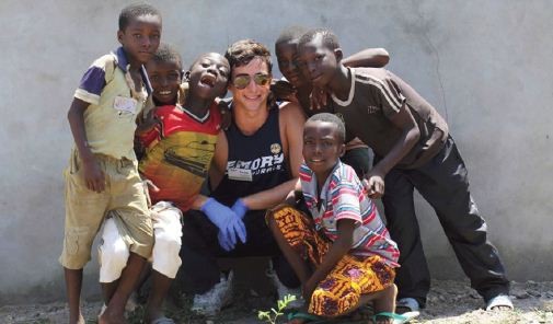 young man posing with African boys in volunteer effort