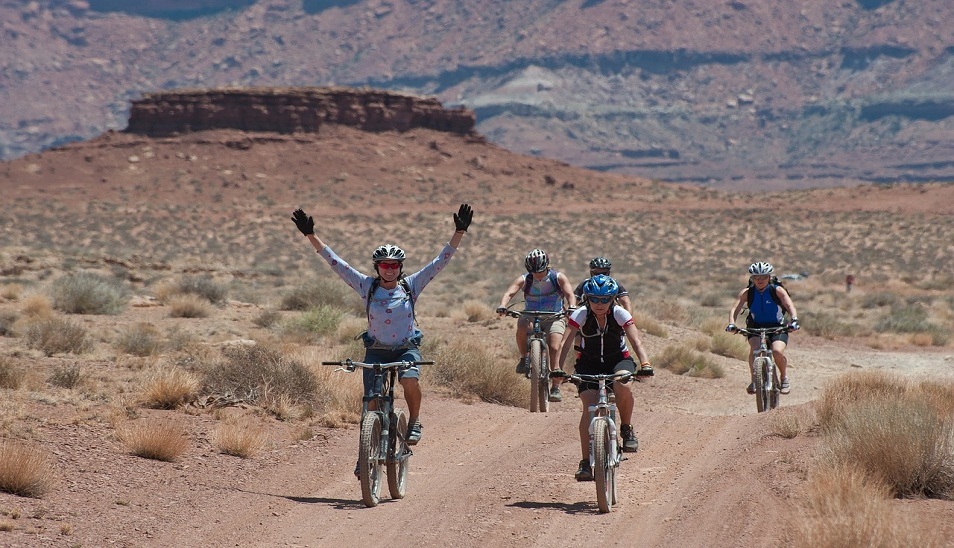 cyclists riding through desert