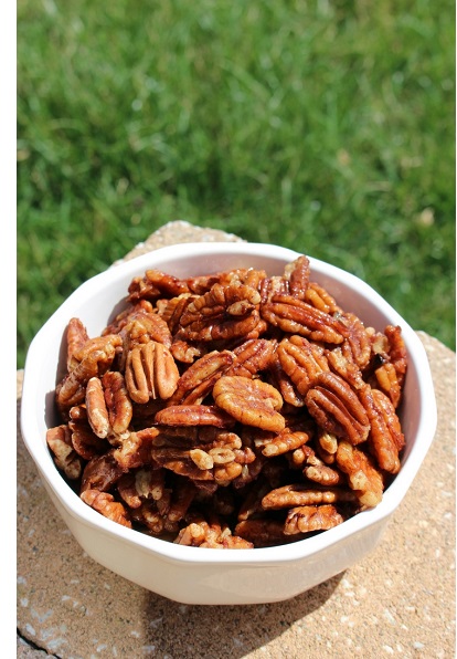 white bowl full of pecans on stone slab with grass background
