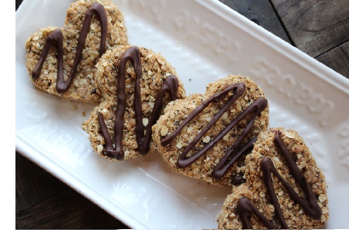 heart shaped, home made granola bars, with chocolate swirls on white plate
