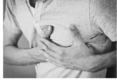 black and white photo of man clutching chest in pain