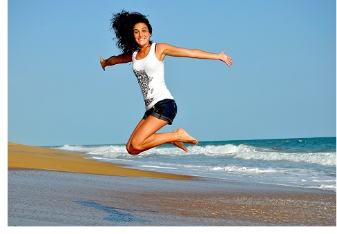 young woman jumping in excitement on the beach