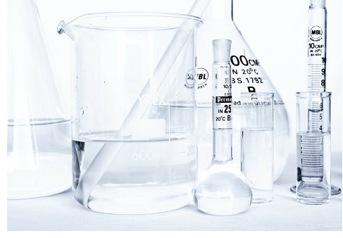 lab testing equipment such as beakers and syringes half full of liquid against white background